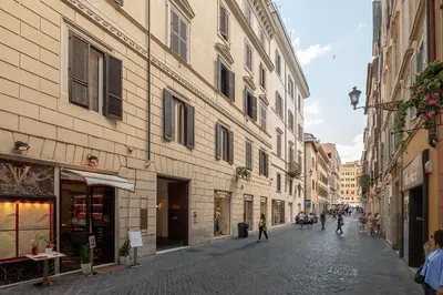 a street with buildings and people walking down a street at Frattina Cozy Flat Spanish Steps in Rome