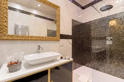 a bathroom with a sink and a mirror and a shower at Piazza Venezia appartamento con vista in Rome