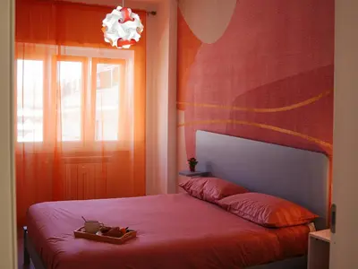 a bedroom with a red bed and a window at La Casa dei Lettori in Rome