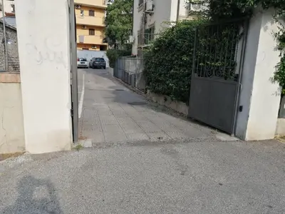 an empty street with a gate on the side of a building at Il Melograno - Just like at home! in Rome