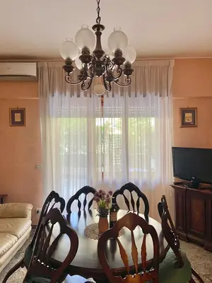 a dining room table with chairs and a chandelier at Aurelio Apartment, Vatican Metro A in Rome