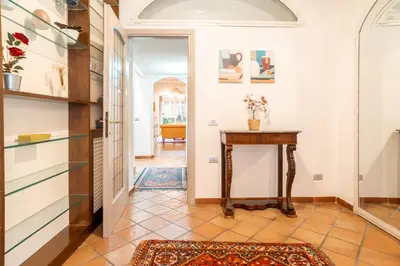 a white kitchen with white cabinets and a refrigerator at Casa Verde - Luxury apartment in Trastevere in Rome