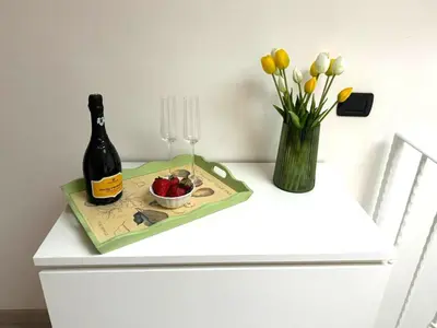 a bottle of champagne and a vase of flowers on a dresser at Duplex Chic in zona trendy in Rome