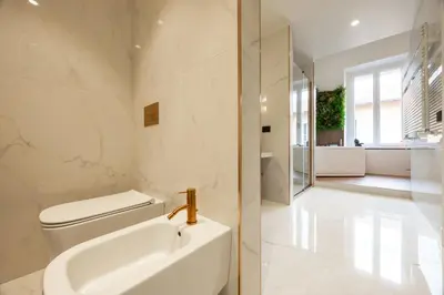 a white bathroom with a toilet and a sink at Casa Lilla in Rome