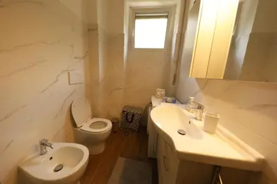 a white bathroom with a toilet and a sink at P-House in Rome