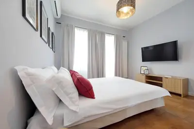 a bedroom with a bed with white sheets and red pillows at Ostiense station penthouse in Rome