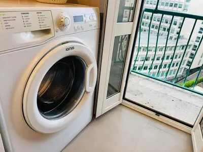 a washing machine in a room with a window at Ostiense station penthouse in Rome