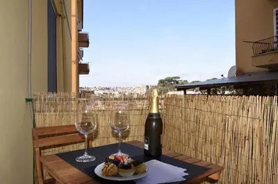 a bottle of wine and two glasses on a table at LG Apartment - Near Vatican City, Rome in Rome