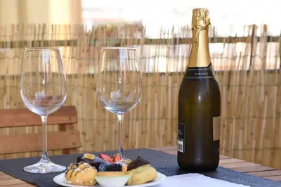 a bottle of wine and two glasses on a table at LG Apartment - Near Vatican City, Rome in Rome