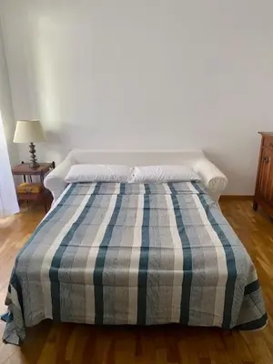 a bed with a blue and white striped comforter in a bedroom at Civico 18 in Rome