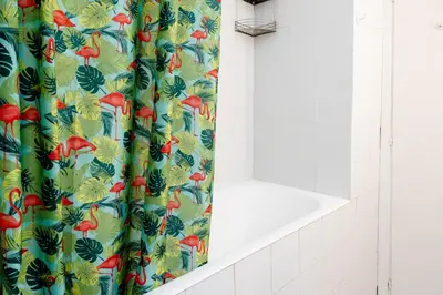 a bathroom with a shower curtain with a tropical bird pattern at Casa Medea in Rome