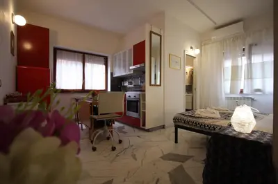 a living room with a table and a kitchen at Rouge studio - 10 min from Vatican in Rome