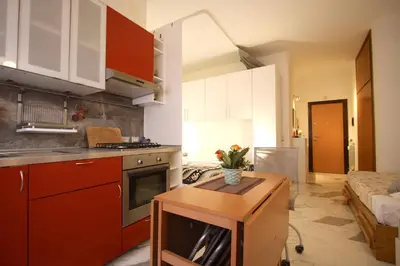 a kitchen with red cabinets and a table in a room at Rouge studio - 10 min from Vatican in Rome