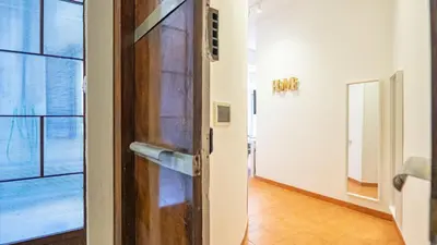 a wooden door in a room with a hallway at EasyTopStay - San Pietro Apartment with Courtyard in Rome