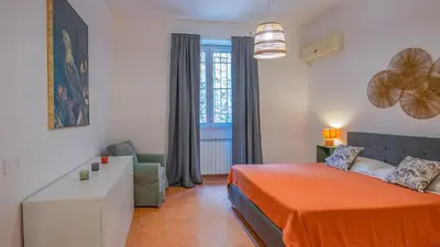 a bedroom with a bed and a desk and a window at EasyTopStay - San Pietro Apartment with Courtyard in Rome