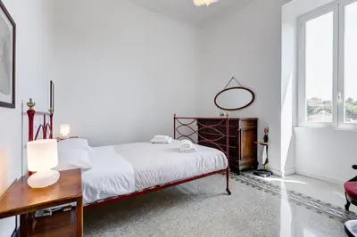 a white bedroom with a bed and a desk at Elegant 3-Bedroom Apartment in Piazza Mazzini in Rome