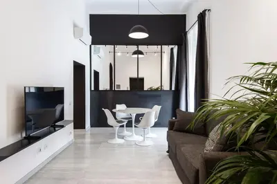 a living room with a couch and a table and a tv at Maison Ottaviano -Vatican- in Rome