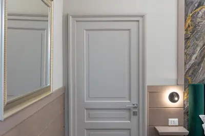a white door in a bathroom with a mirror at Iron Monti Coliseum in Rome