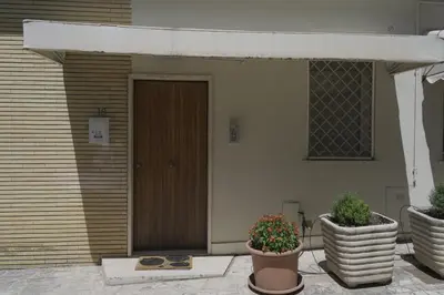 a house with two potted plants in front of a door at Daniela's Home vicino a Metro A e Vaticano in Rome
