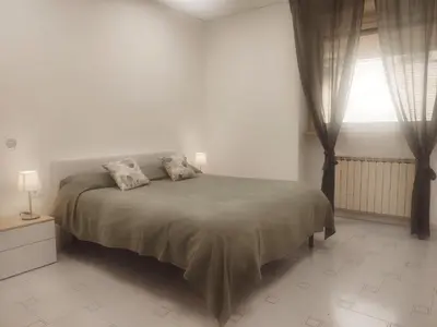 a white bedroom with a bed and a window at Daniela's Home vicino a Metro A e Vaticano in Rome