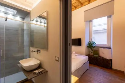 a bathroom with a bed and a sink and a mirror at Fontana di Trevi Roma Luxury in Rome