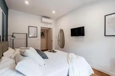 a white bedroom with a large bed with white pillows at The Best Rent - Refined multi-room apartment in Termini area in Rome