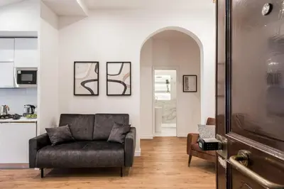 a living room with a couch and a kitchen at The Best Rent - Refined multi-room apartment in Termini area in Rome