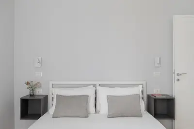 a bedroom with a white bed with two night stands at iFlat La Dolce Vita - Contemporary Luxury in Rome in Rome