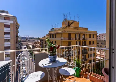 a balcony with a table and chairs and a view of a city at AMORE MIO - Art House in Rome