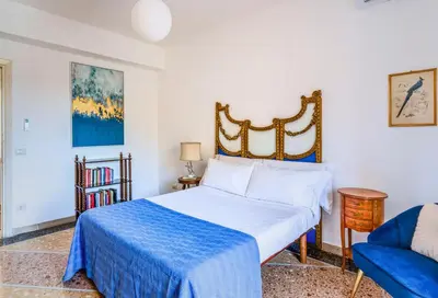 a bedroom with a bed and a blue chair at AMORE MIO - Art House in Rome