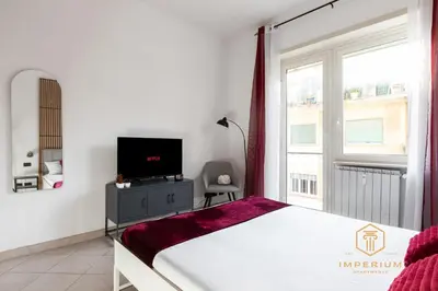 a bedroom with a bed and a tv and a window at Teano Apt - 10min to Colosseo, 100mt to metro, A-C, 2 Bedrooms in Rome