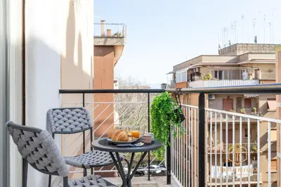 a small balcony with a table and two chairs at Teano Apt - 10min to Colosseo, 100mt to metro, A-C, 2 Bedrooms in Rome