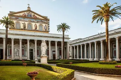 a large building with palm trees in front of it at City Lights Rome in Rome