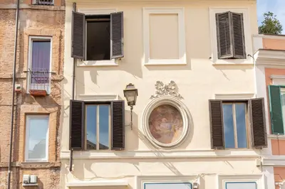 a building with shuttered windows and a clock on it at Trastevere Charming Apartment by RomeLoft in Rome
