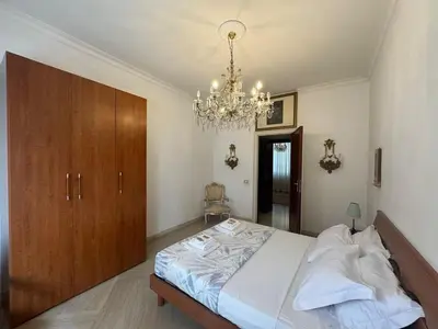a bedroom with a large bed and a chandelier at Spacious Getaway with Roman Charm in Rome