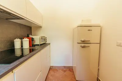 a small kitchen with a refrigerator and a microwave at Casa di NOAH in Rome