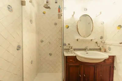 a bathroom with a sink and a shower with a mirror at Casa di NOAH in Rome