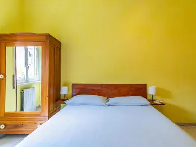 a bedroom with a large bed and a yellow wall at Casa Lo Vercio in Rome