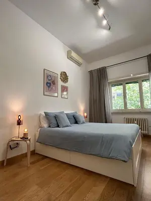 a bedroom with a large bed with blue pillows at MarVal Vatican House in Rome