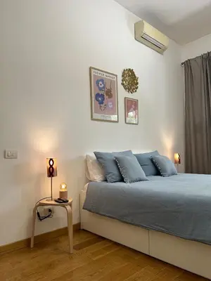 a bedroom with a bed with blue pillows and a table at MarVal Vatican House in Rome