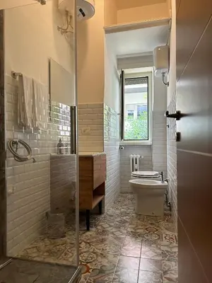 a bathroom with a toilet and a sink and a window at MarVal Vatican House in Rome