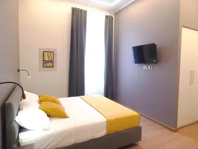 a bedroom with a bed with a tv on the wall at Domus Quintili Monti in Rome