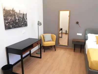 a room with a desk and a bed and a mirror at Domus Quintili Monti in Rome