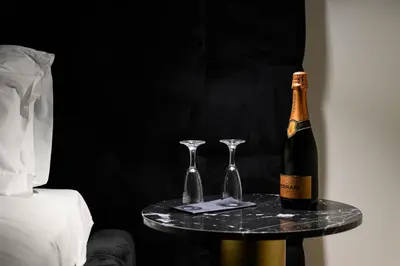 a bottle of champagne and two glasses on a table at Rome Elegant Suite in Rome
