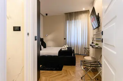 a bedroom with a bed and a chair in a room at Rome Elegant Suite in Rome
