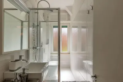 a white bathroom with a shower and a sink at GuestHost - Bright Flat in Lungotevere Flaminio in Rome