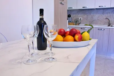 a table with two wine glasses and a bowl of fruit at Nala's Vatican House in Rome