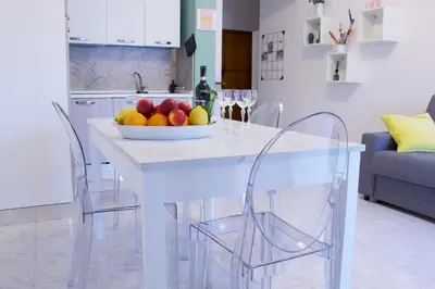 a white kitchen with a bowl of fruit on a table at Nala's Vatican House in Rome