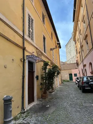 an alley with a building and a street with cars at Suite at the Coliseum in Rome