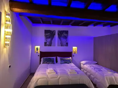 a bedroom with two beds with purple lighting at Suite at the Coliseum in Rome